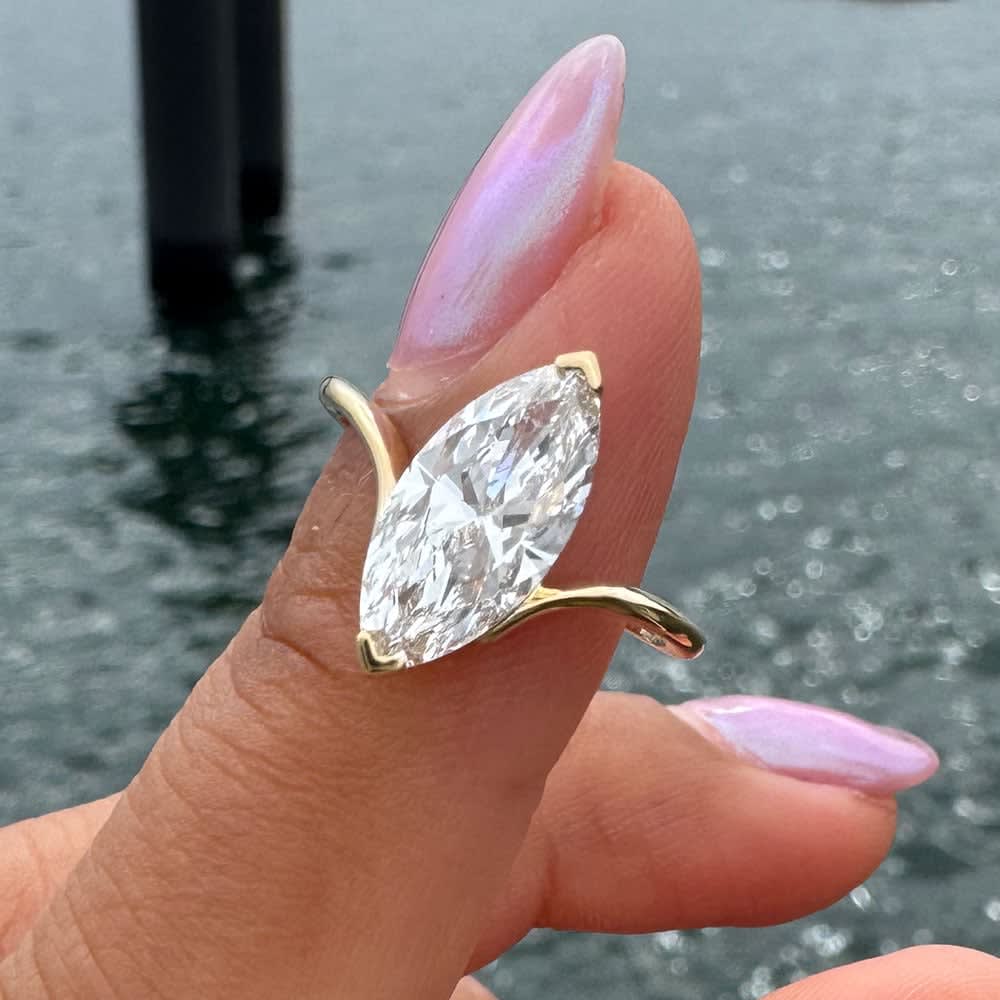 Petite engagement ring set with marquise cut diamond