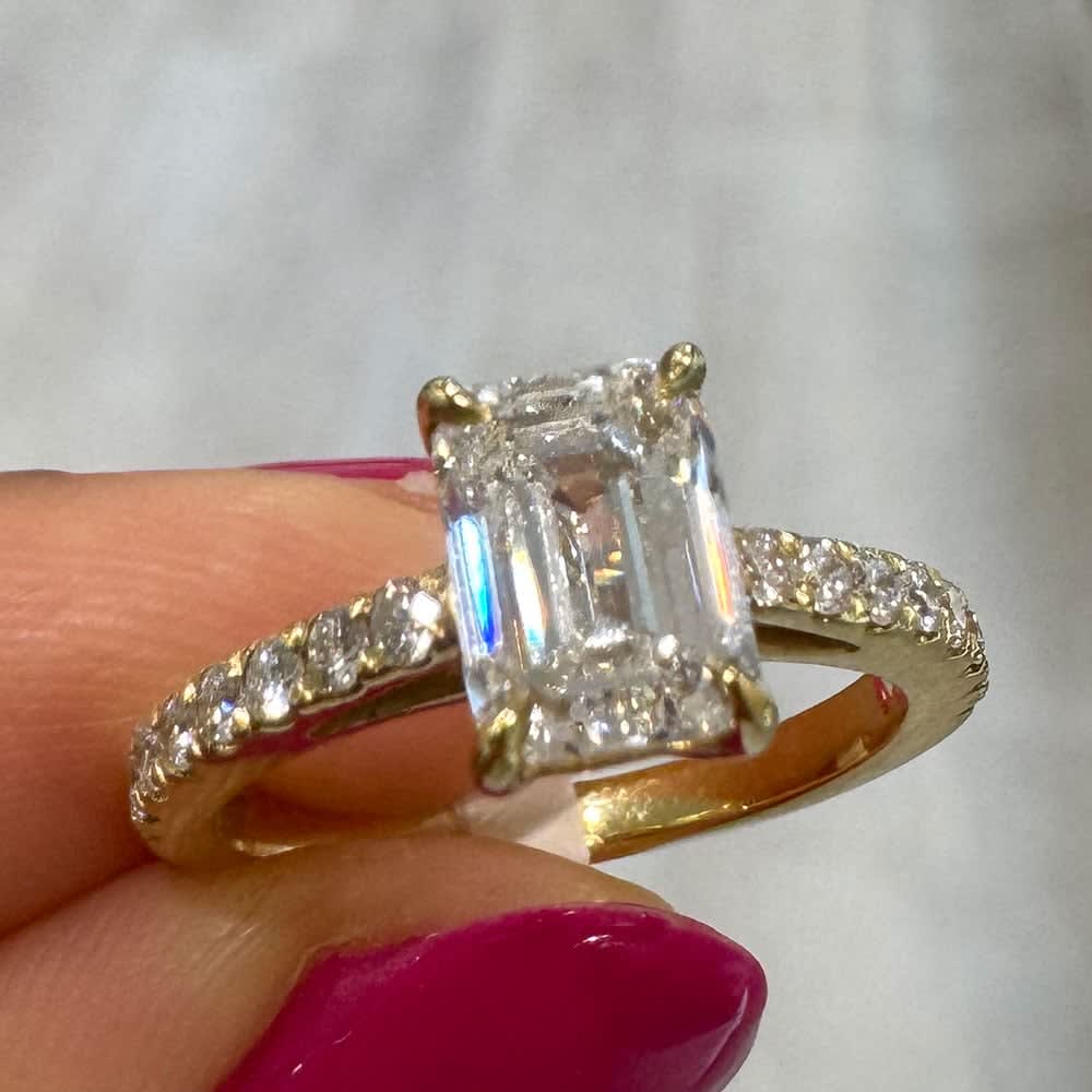 Emerald cut on a diamond band yellow gold