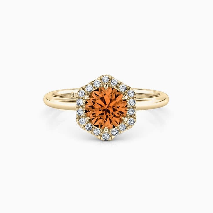Round Brilliant cut Orange Sapphire with a hexagon shape halo