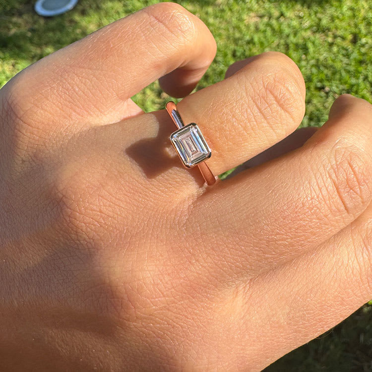 East west bezel set emerald cut engagement ring
