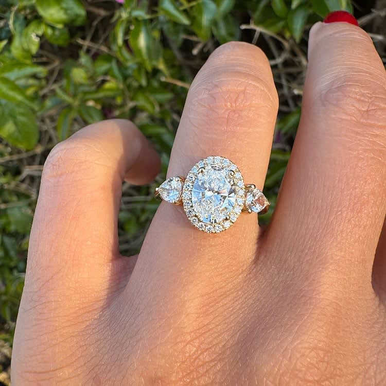 Oval diamond with halo and trilogy setting