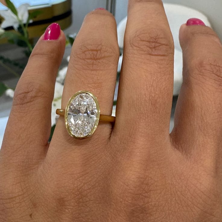 Oval diamond set in bezel setting in yellow gold