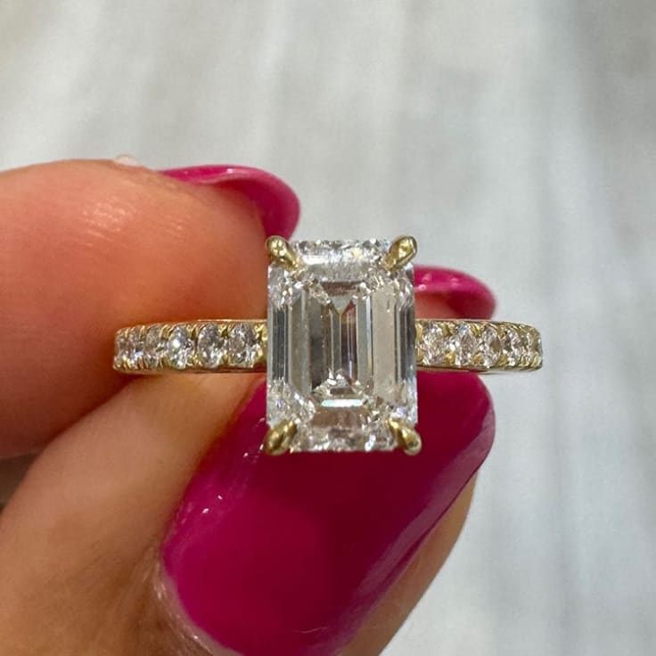 Emerald cut on a diamond band yellow gold