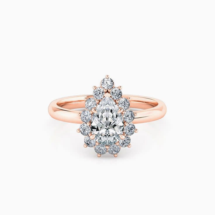 Pear cut diamond engagement ring with a floral diamond halo