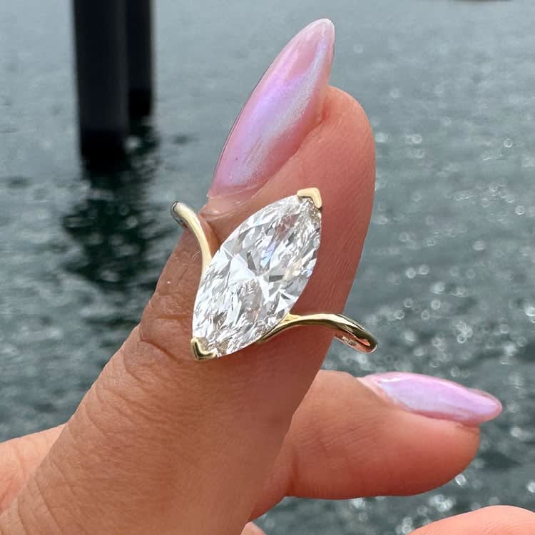 Petite engagement ring set with marquise cut diamond