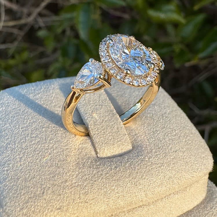 Oval diamond with halo and trilogy setting