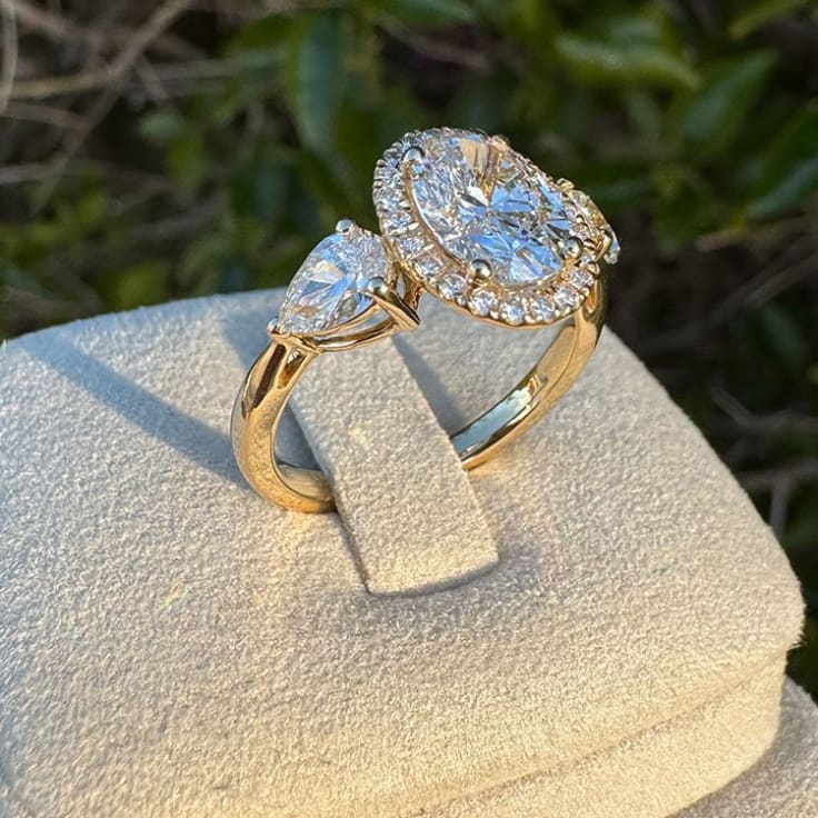 Oval diamond with halo and trilogy setting